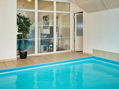 a large swimming pool in a room with a house at 18 person holiday home in Ulfborg in Øby