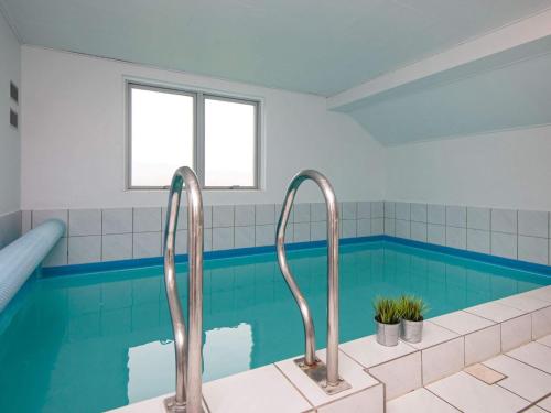 a bathroom with a swimming pool with two faucets at 10 person holiday home in Juelsminde in Sønderby