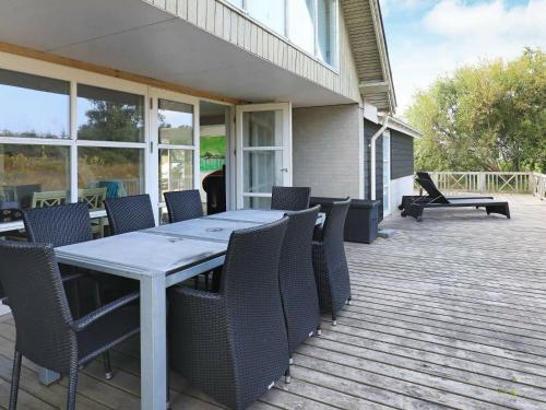 a patio with a table and chairs on a deck at 8 person holiday home in Ulfborg in Fjand Gårde