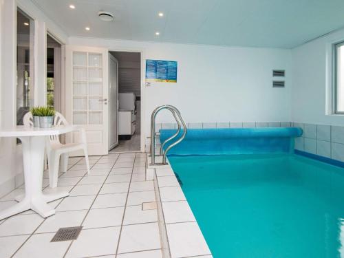 a swimming pool in a bathroom with a table and a sink at 10 person holiday home in Juelsminde in Sønderby