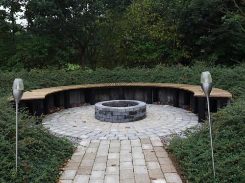 a fire pit in a garden with two lights at 14 person holiday home in H jslev in Bøstrup