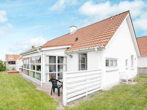 una casa blanca con una silla negra en el patio en 10 person holiday home in Thisted, en Klitmøller