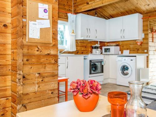 a kitchen with white appliances and a vase with flowers on a table at 4 person holiday home in Skjern in Lem