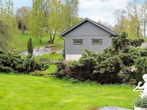 ein graues Haus auf einem Feld mit einem Hof in der Unterkunft 5 person holiday home in ASKER ARNA in Buvik