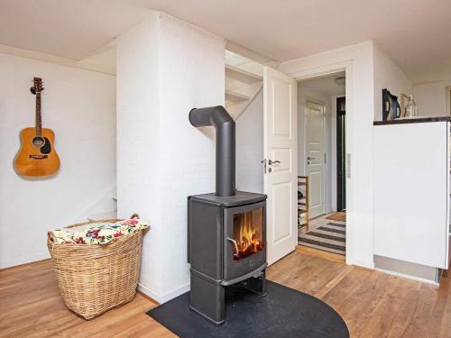 Skødshoved Strandにある6 person holiday home in Knebelの暖炉付きのリビングルーム(ギター付)