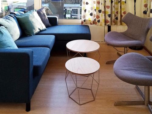 sala de estar con sofá azul y 2 mesas en 6 person holiday home in Hejls, en Hejls