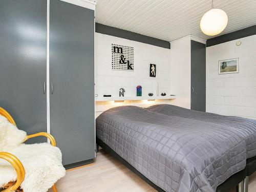 a bedroom with a gray bed and a chair at Two-Bedroom Holiday home in Jerup 6 in Jerup