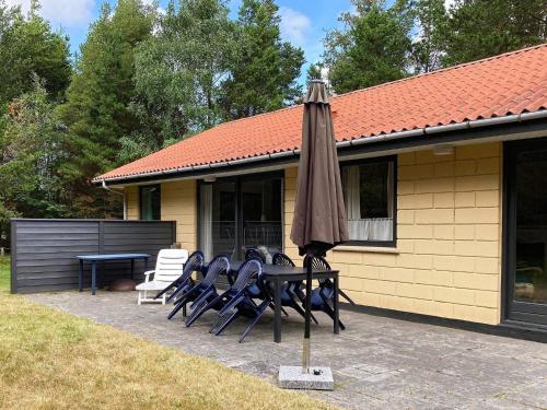 a table with an umbrella next to a house at 8 person holiday home in Bl vand in Ho
