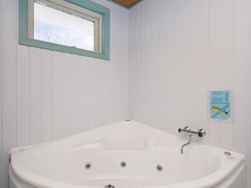 a white bath tub in a bathroom with a window at 8 person holiday home in Bl vand in Ho