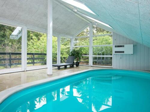 una piscina vacía en una casa con ventanas en 6 person holiday home in Ebeltoft, en Øksenmølle