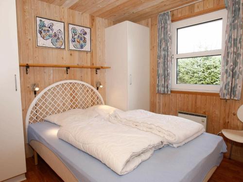 ein Schlafzimmer mit einem Bett in einem Zimmer mit einem Fenster in der Unterkunft Four-Bedroom Holiday home in Hadsund 26 in Nørre Hurup