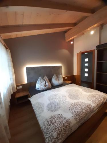 a bedroom with a large bed with pillows on it at Appartement Alexandra in Neukirchen am Großvenediger