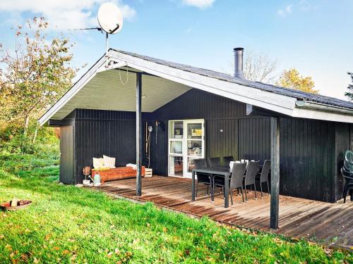 Skødshoved Strandにある6 person holiday home in Knebelの木製デッキ(テーブル、椅子付)が備わる家