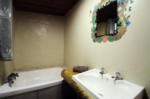 Baño con 2 lavabos y espejo en la pared en Away with the Fairies, en Hogsback