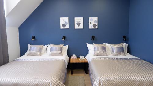 two beds in a room with a blue wall at Mina Hotel Arbat in Vladivostok