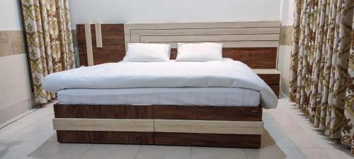 a bedroom with a large bed with white sheets at SWAT GUEST HOUSE in Mingora