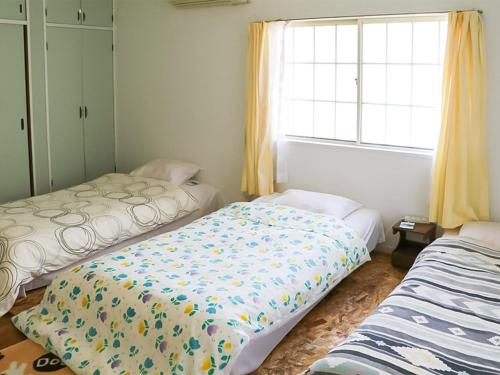 Postel nebo postele na pokoji v ubytování Guest House Shirahama R-cafe - Female Only