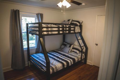 two bunk beds in a room with a window at Modern Cottage Near Hospitals and Brewery! in Morganton