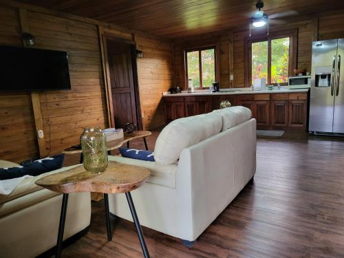 een woonkamer met een witte bank en een tafel bij Private Mountaintop Cabin in Carara Biological Corridor 20 minutes to beaches in Carara
