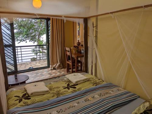 a bedroom with a bed with a window and a table at Avocado Bay Private Retreat in Entebbe