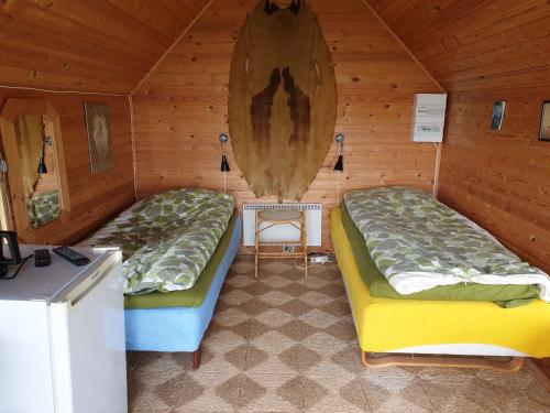 a room with two beds in a wooden cabin at Sunrise in Tappernøje