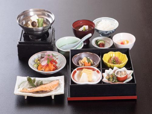 a tray filled with different types of food on a table at Nakatsugawa Onsen Hotel Hanasarasa in Ochiai