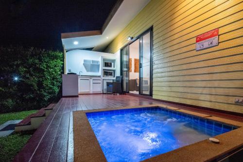 a swimming pool in front of a house at night at Moon Cottage in Choeng Mon Beach