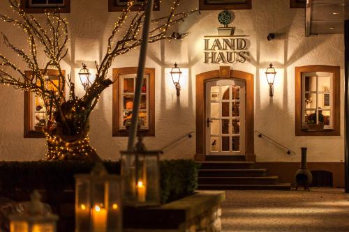 - un bâtiment avec un panneau indiquant le Land haus avec des lumières dans l'établissement Romantik Hotel Landschloss Fasanerie, à Zweibrücken