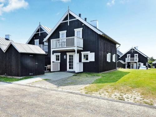 a large black barn with a white at 8 person holiday home in Gjern in Gjern