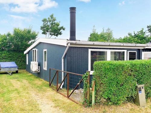 ein blaues Haus mit einem Kamin darüber in der Unterkunft 4 person holiday home in Broager in Broager
