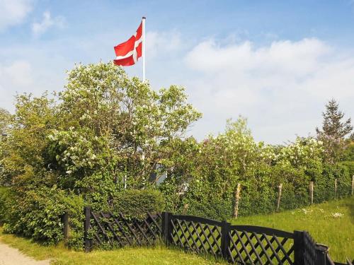 una bandera canadiense ondeando sobre una valla en un campo en 4 person holiday home in Broager en Broager