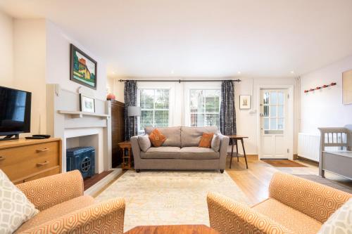 a living room with a couch and a television at Delightful Bird Sisters Cottage with Free Parking in Brighton & Hove