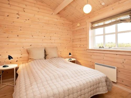 1 dormitorio con 1 cama en una habitación de madera en Holiday Home Smørblomstvænget, en Humble