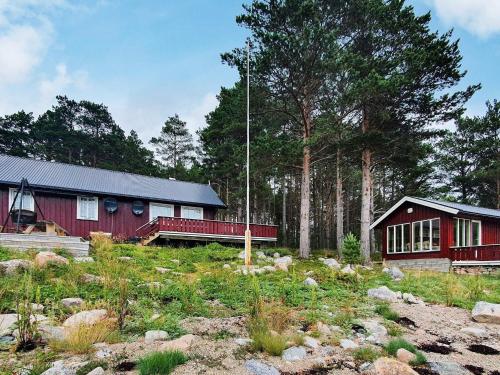 a red house in the middle of a forest at 8 person holiday home in Sundlandet in Snildal