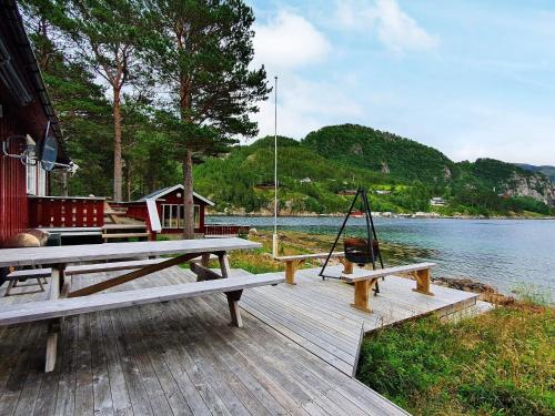 a wooden deck with a picnic table and a swing at 8 person holiday home in Sundlandet in Snildal