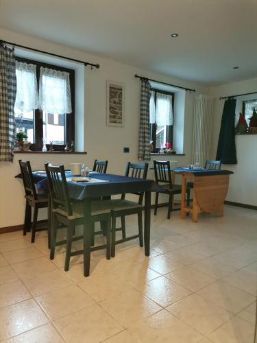 Un comedor con mesa y sillas y ventanas. en ManuEbbasta, en Scopello