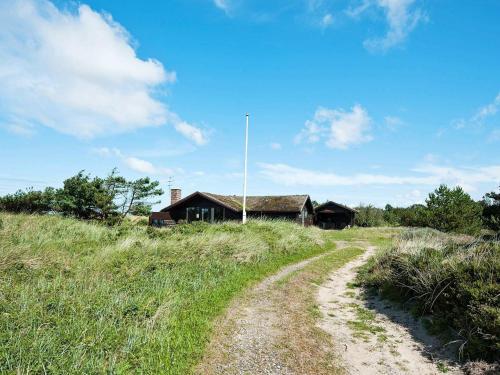 un chemin de terre devant une maison sur une colline dans l'établissement 6 person holiday home in R m, à Toftum