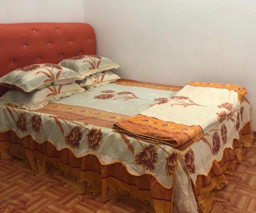 太平HOMESTAY CIK MUNAH的一张带红色床头板和枕头的床