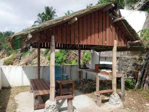 a small hut with a chair and a table at MLK Bamboo Beachhouse in Alegria