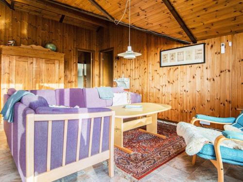 un soggiorno con divano e tavolo di 6 person holiday home in R m a Toftum