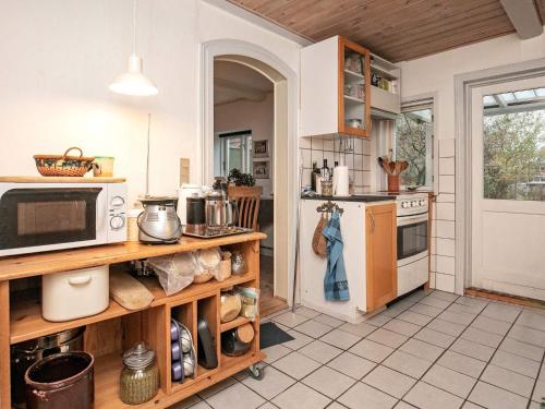 ルーケベングにある4 person holiday home in Rudk bingのキッチン(コンロ、電子レンジ付)