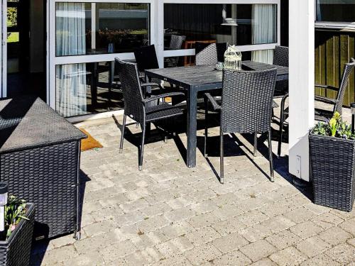 Ertebølleにある9 person holiday home in Farsのパティオ(黒いテーブルと椅子付)
