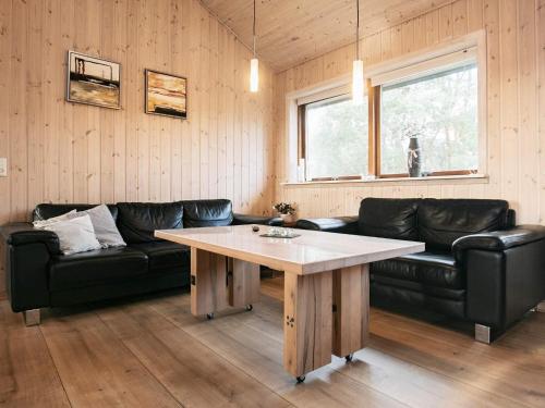 Nørre Lyngbyにある8 person holiday home in L kkenのリビングルーム(黒い革張りのソファ、テーブル付)