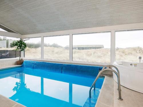 uma grande piscina com uma banheira e uma banheira em 12 person holiday home in L kken em Grønhøj