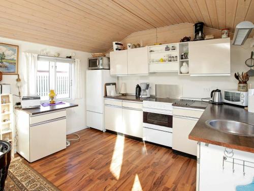 een keuken met witte apparatuur en een houten plafond bij 4 person holiday home in Mesinge in Mesinge