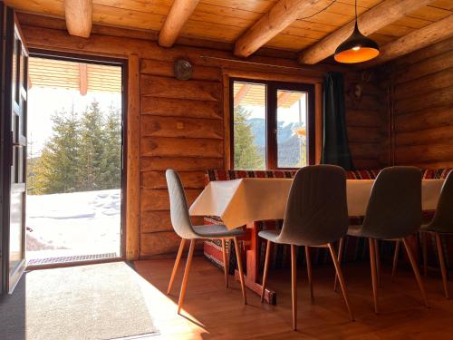 a dining room with a table and chairs at Cabana Lupilor in Tău Bistra