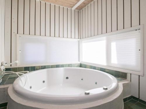 Ålbækにある6 person holiday home in lb kのバスルーム(大きな白いバスタブ、2つの窓付)