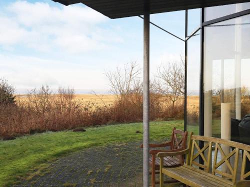 a bench sitting on a porch with a view of a field at 10 person holiday home in H jslev in Højslev