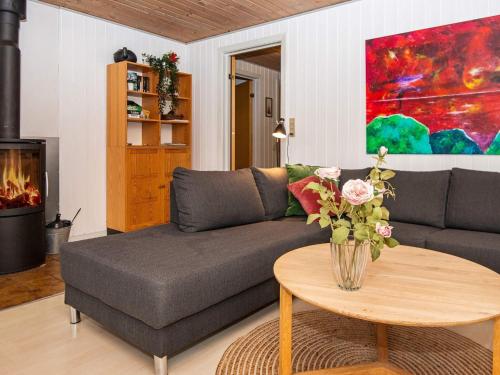 a living room with a couch and a table with flowers at 6 person holiday home in Hemmet in Hemmet