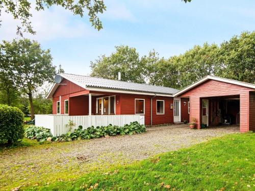 a red house with a white fence at 6 person holiday home in Hemmet in Hemmet